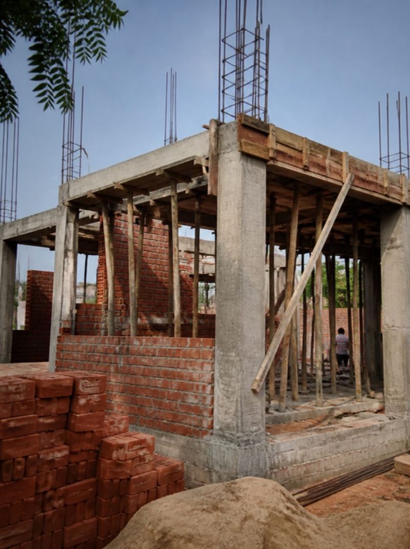 A house under construction with a concrete frame and brick walls